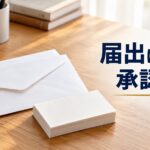 机に置かれた転居の封筒と、その横の新しい名刺の束