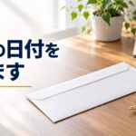 机に置かれた白い封筒と万年筆、横に卓上カレンダー