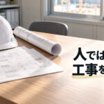工事現場の朝、事務所の机に置かれた注文書と図面