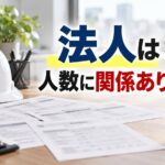 事務所の机に広げた社会保険の届出書類と、その横のヘルメット